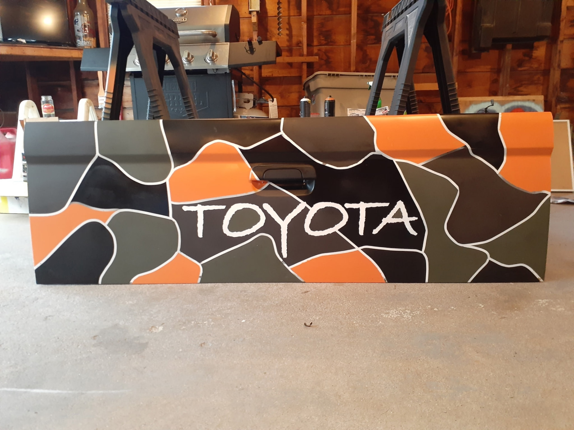 Hand-painted Toyota truck panel in black, gray, and orange